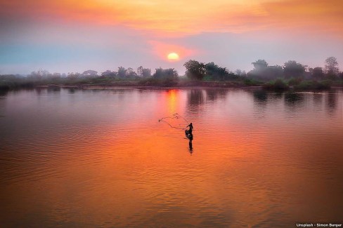 Pêcheur au coucher de soleil sur le Mékong